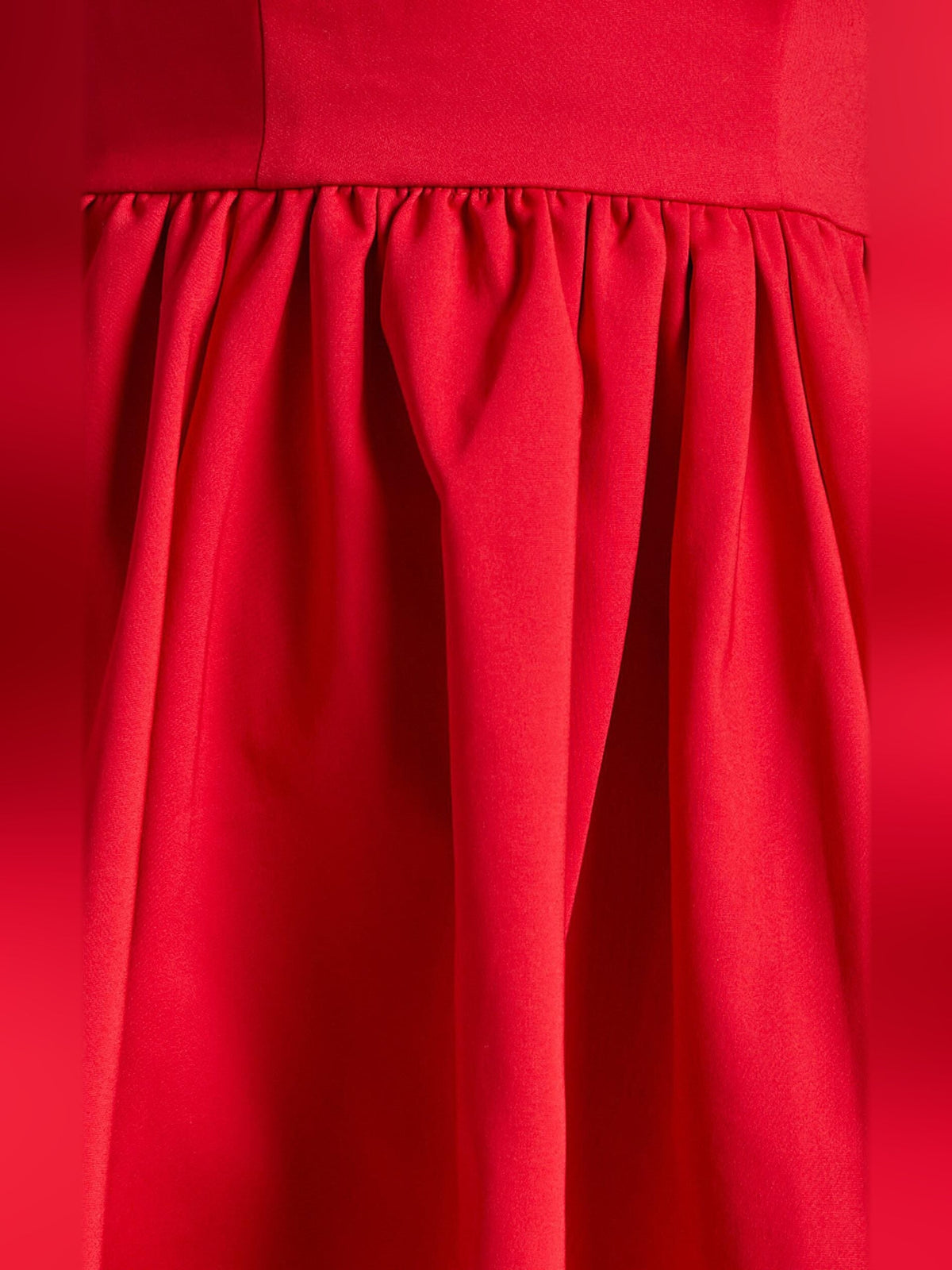 Red gathered skirt with pleated panels below the waist