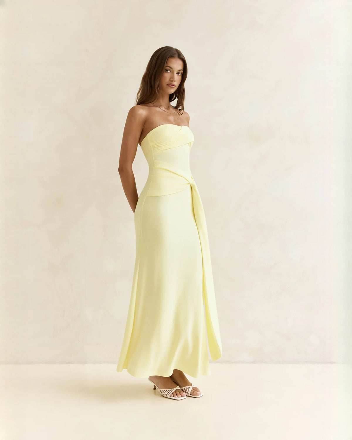Light yellow strapless satin A-line maxi dress with draped waist and gently flared hem