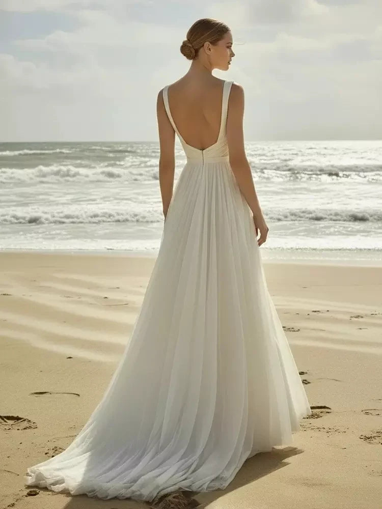 Ivory chiffon A-line wedding dress from back with open back and flowing pleated train