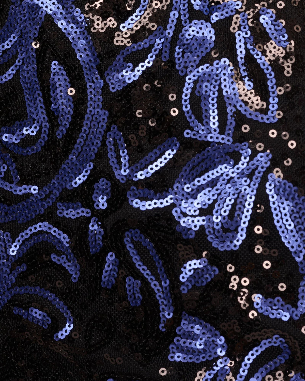 Close-up of navy-blue sequin fabric with swirling pattern and light-reflecting sequins