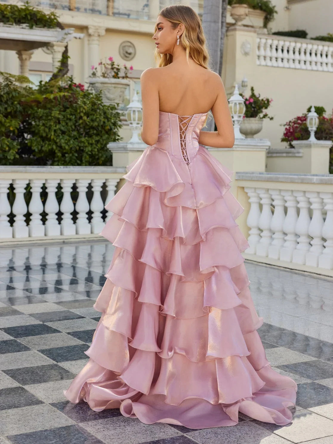 Light pink tiered corset ball gown with open back and layered ruffle skirt