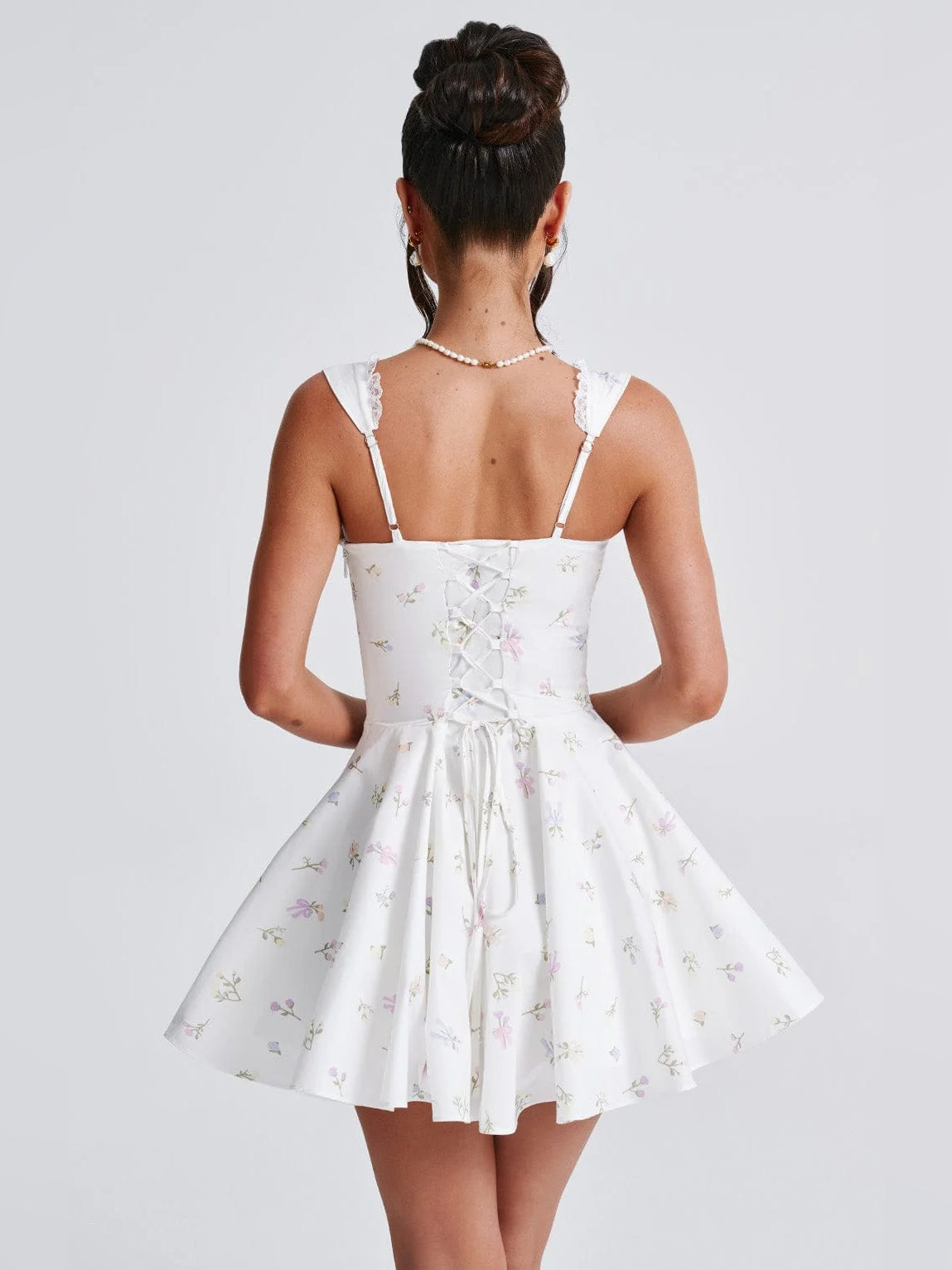 White mini dress with floral print, open-back look with lace-trim straps and gathered waist