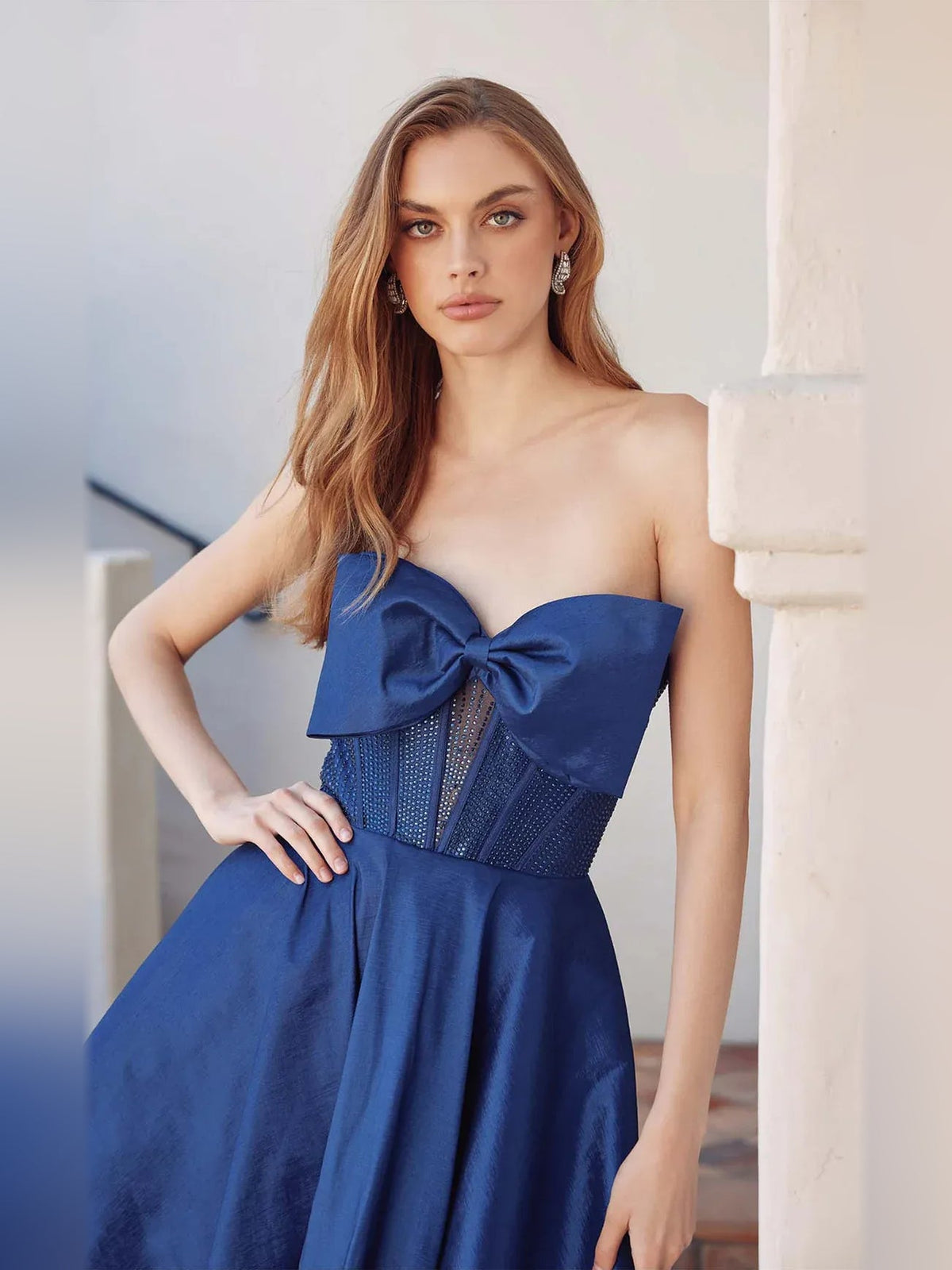 Dark blue strapless satin mini dress with corset bodice, bow, and sheer panel detail