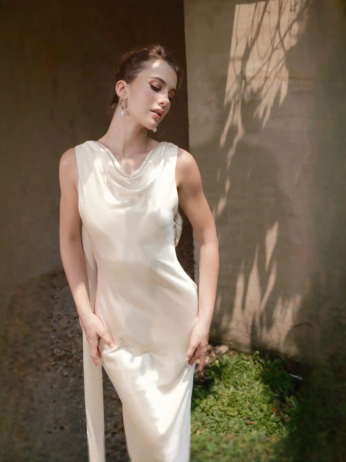 Ivory satin draped cowl-neck sheath wedding dress with sleeveless silhouette