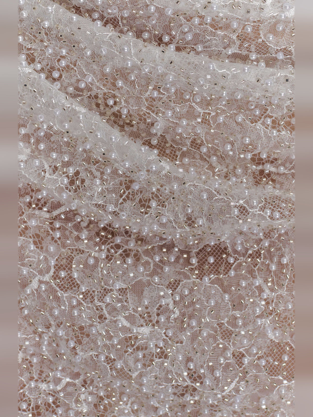 Close-up of nude beaded sequin fabric on an off-shoulder mini dress