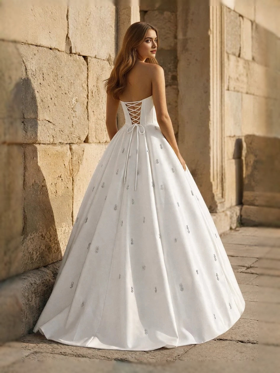 Ivory sweetheart corset ball gown with thin straps and full floor-length skirt, front view
