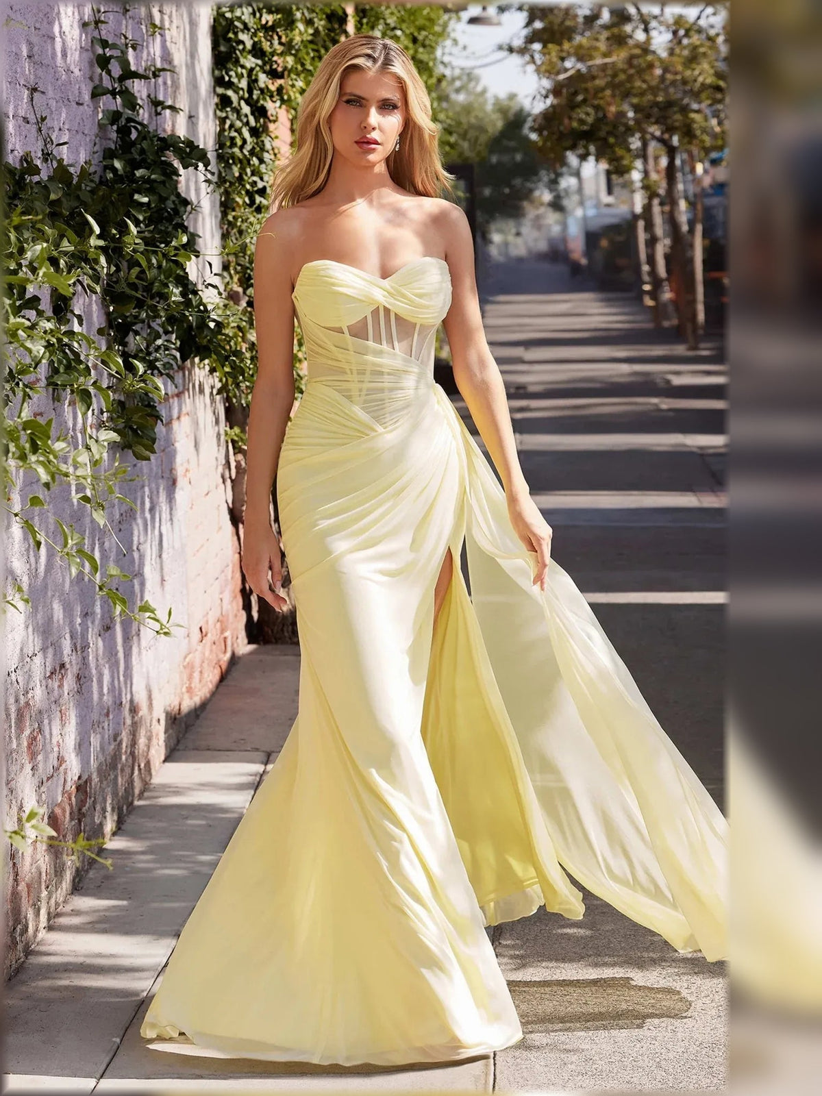 Light yellow strapless corset formal dress with ruched draping and thigh-high front slit