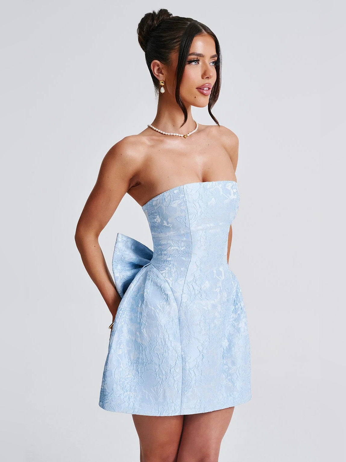 Blue strapless mini dress side view with structured bodice and flared skirt.