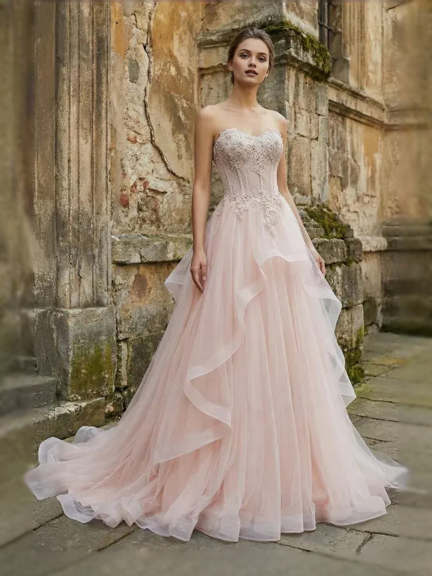 Blush pink strapless sweetheart ball gown with layered tulle skirt and corset bodice