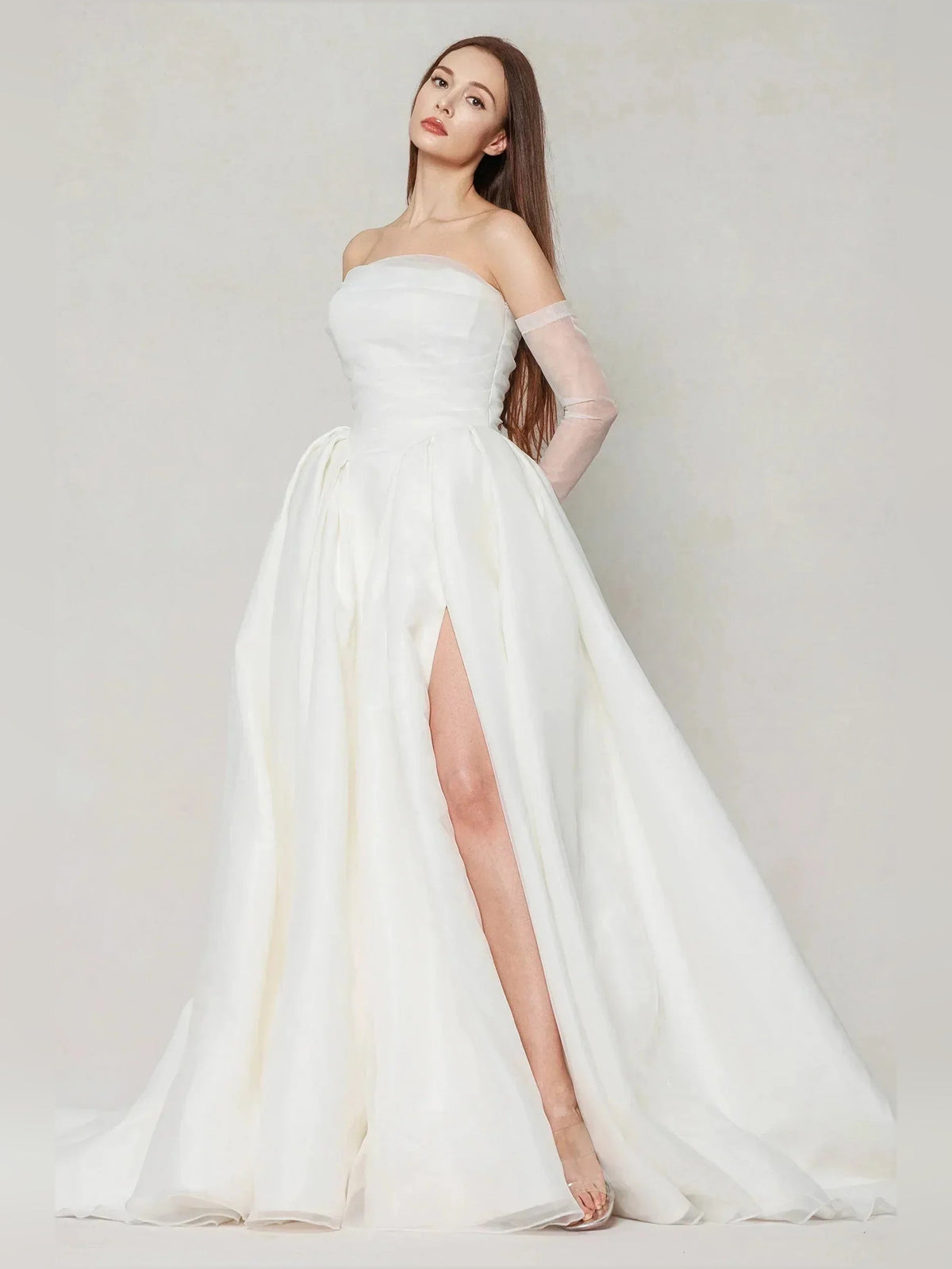 Ivory strapless wedding dress with pleated skirt and side slit, flowing train