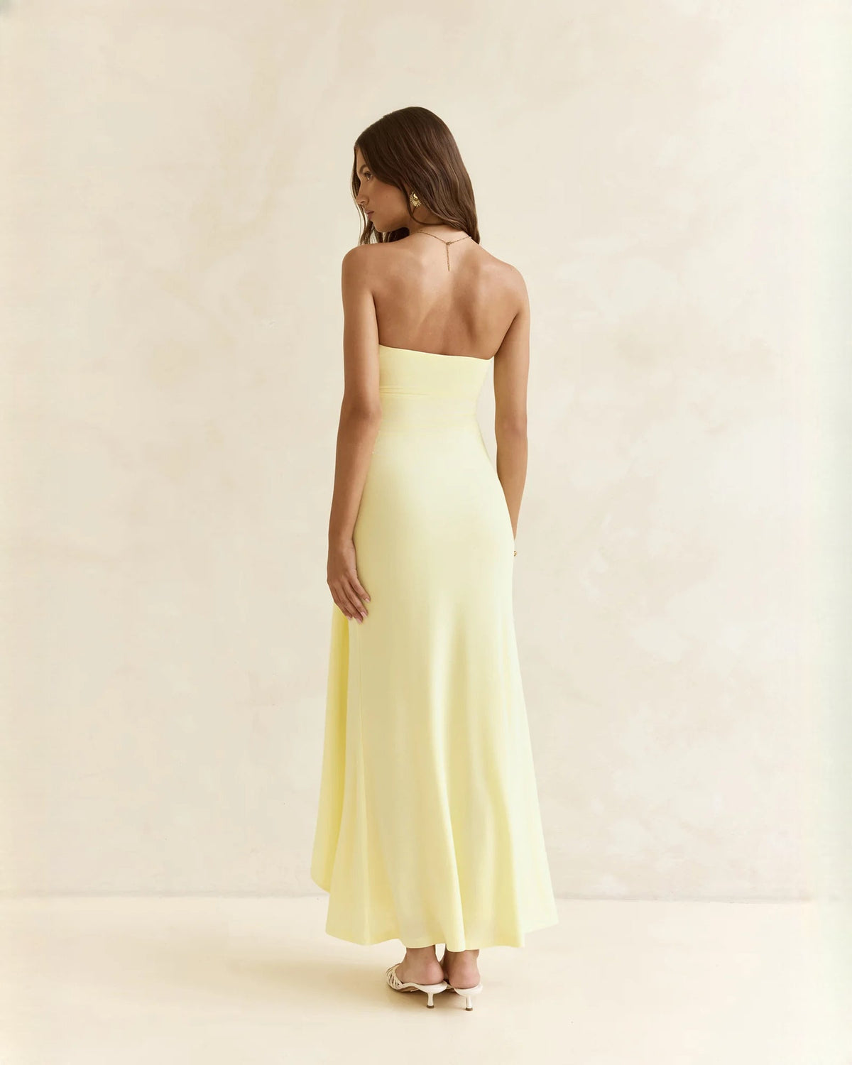 Light yellow strapless satin A-line maxi dress, open back and flowing floor-length skirt