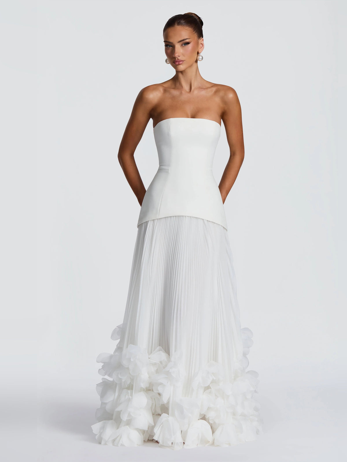 Ivory strapless wedding dress with pleated skirt and layered floral ruffle accents at hem