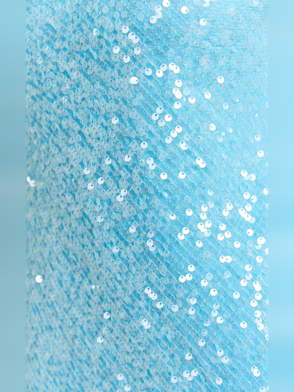 Close-up of blue sequin fabric with scattered metallic sparkle