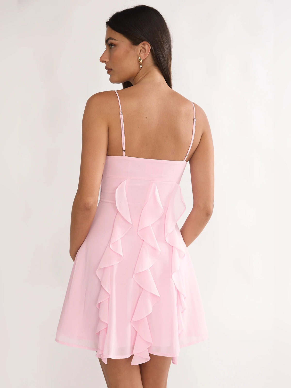 Blush pink ruffled mini dress with thin spaghetti straps, open back, layered ruffle tiers
