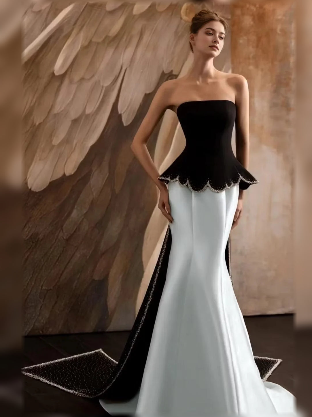 Strapless mermaid formal dress with black bodice, scalloped peplum, white skirt.