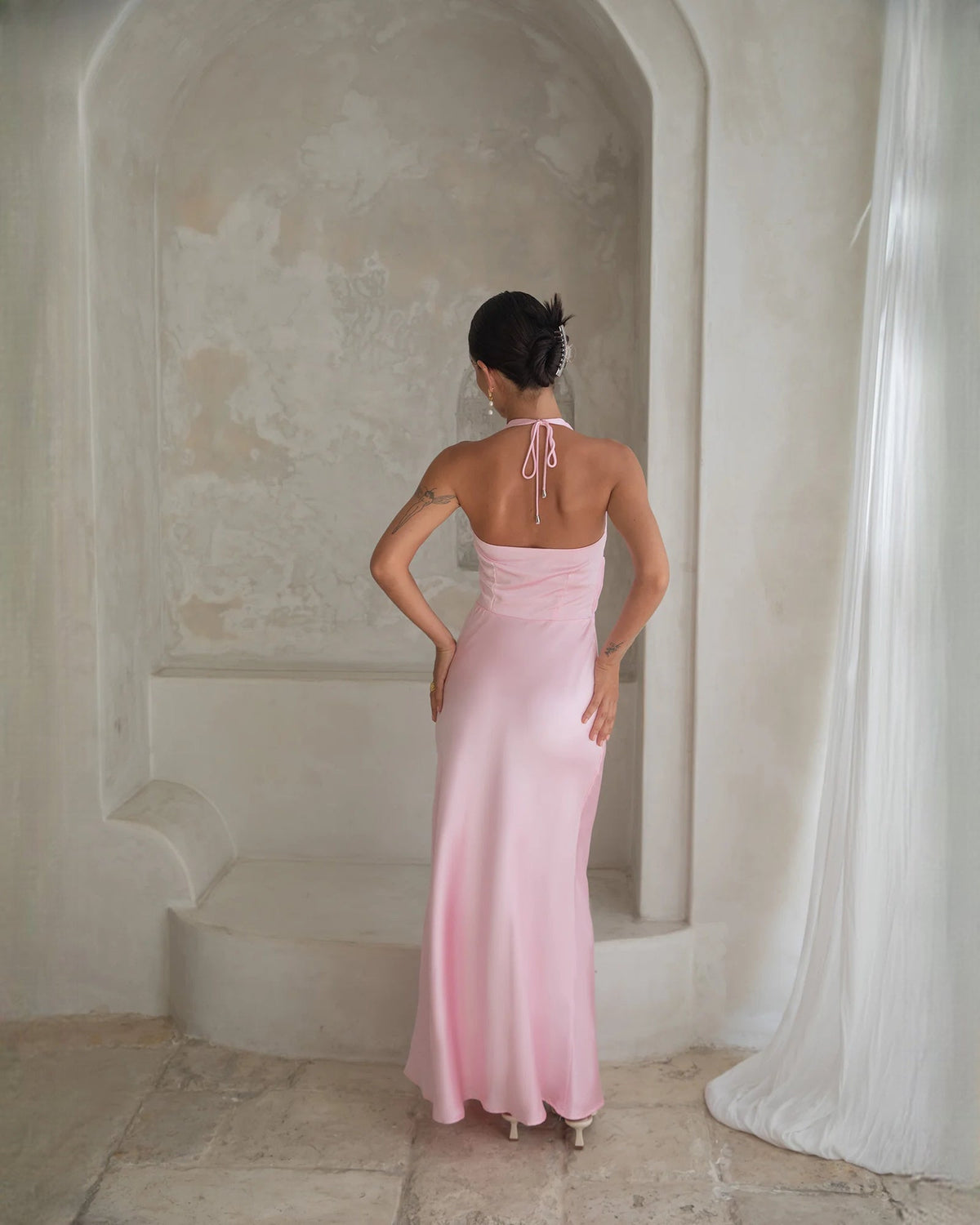 Pale pink satin halter A-line maxi dress shown from back with tie straps