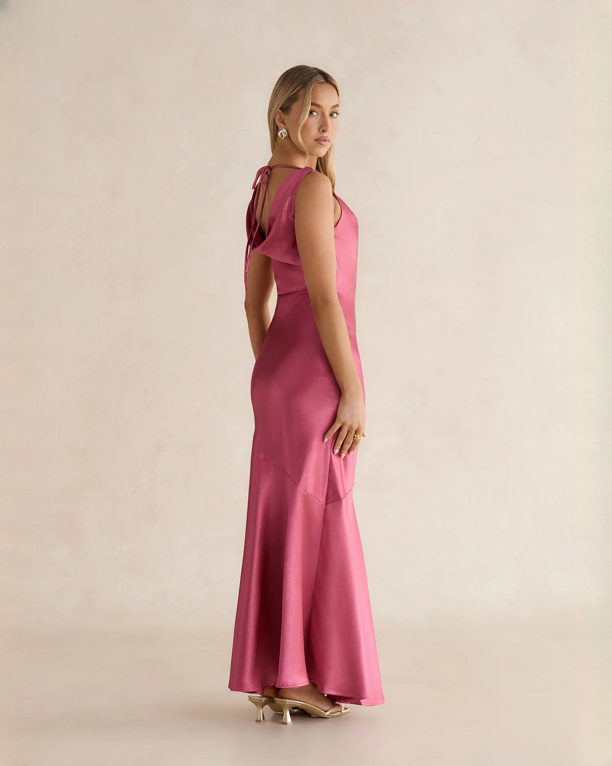 Pink satin maxi dress with open back and tied straps, flared A-line hem
