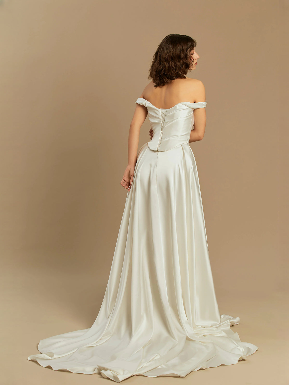Ivory satin floor-length A-line wedding dress from back, draped corset and off-shoulder straps