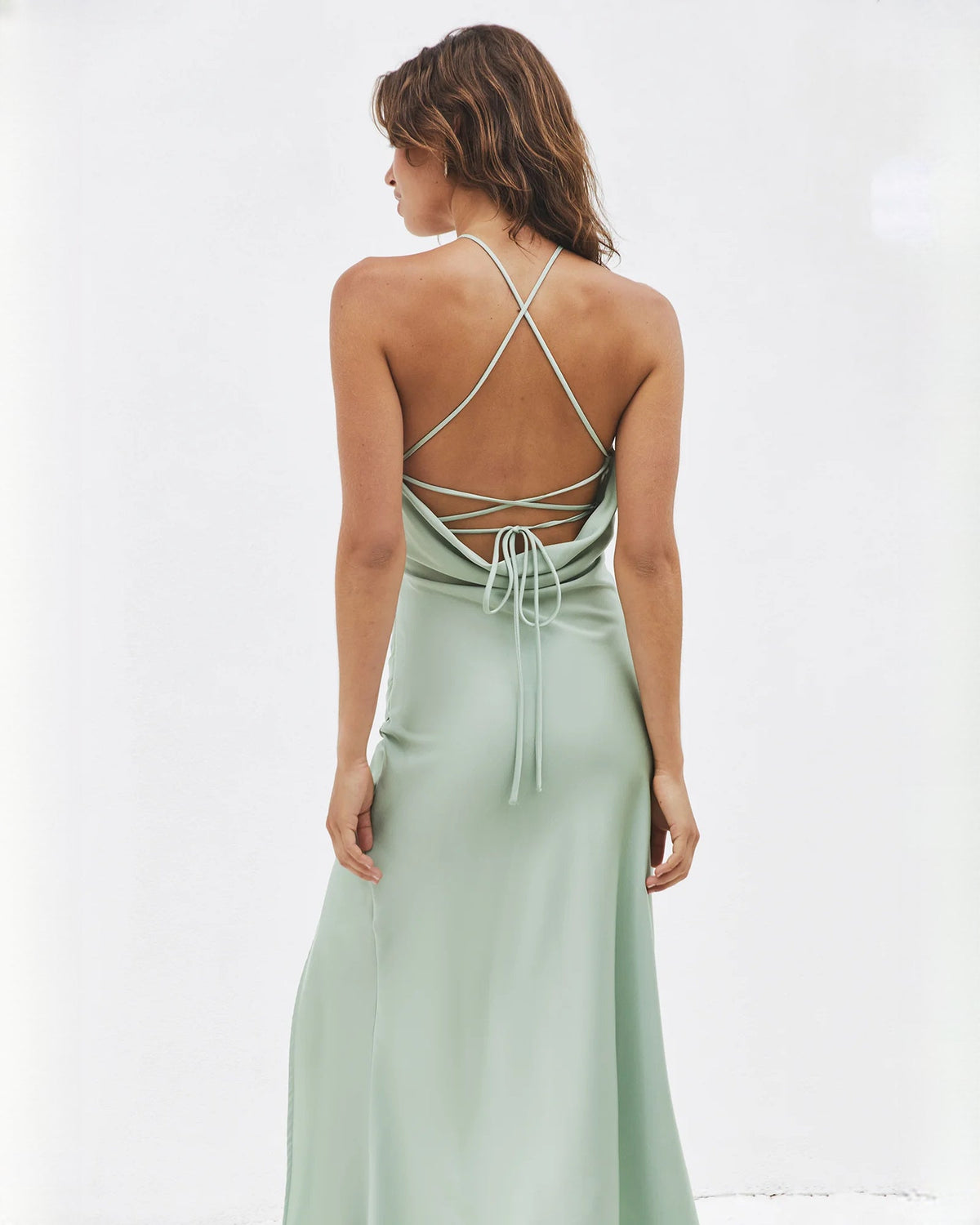 Sage green satin midi dress with crisscross open-back straps and gathered ties