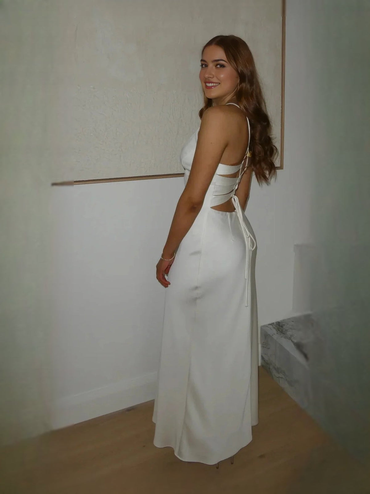 Ivory backless cut-out prom dress with crisscross straps and tie at the back.