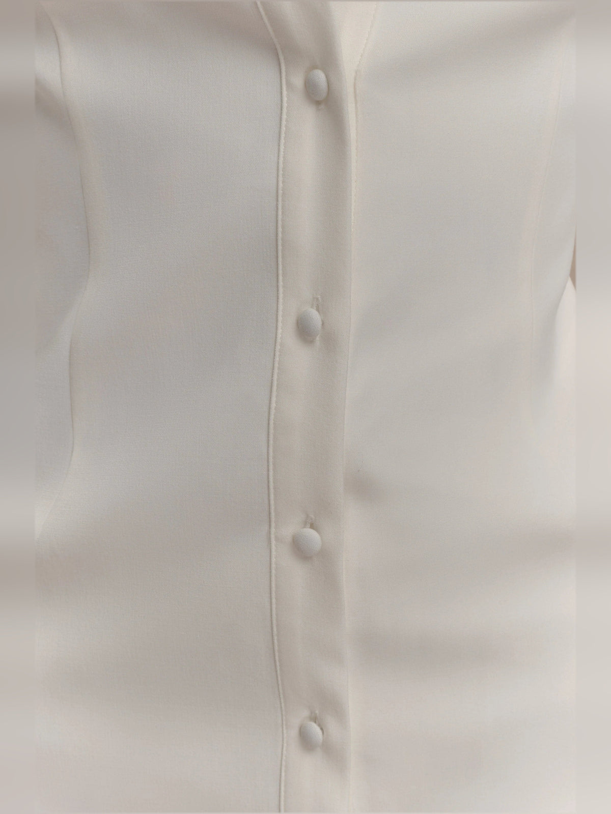 White shirt dress button placket detail with fabric-covered buttons and vertical seam