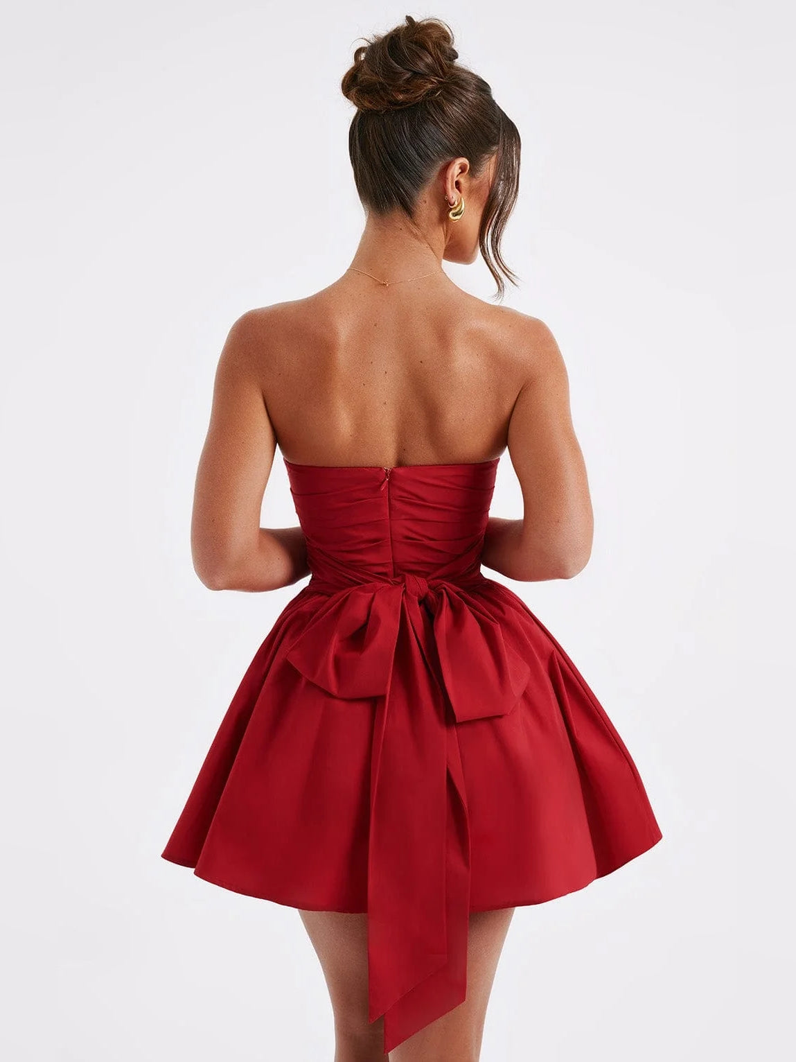 Red strapless mini dress back view with ruched waistband and bow-draped skirt