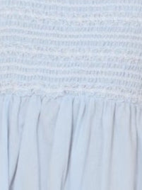 Light blue dress fabric close-up: smocked bodice texture and gathered ruffle
