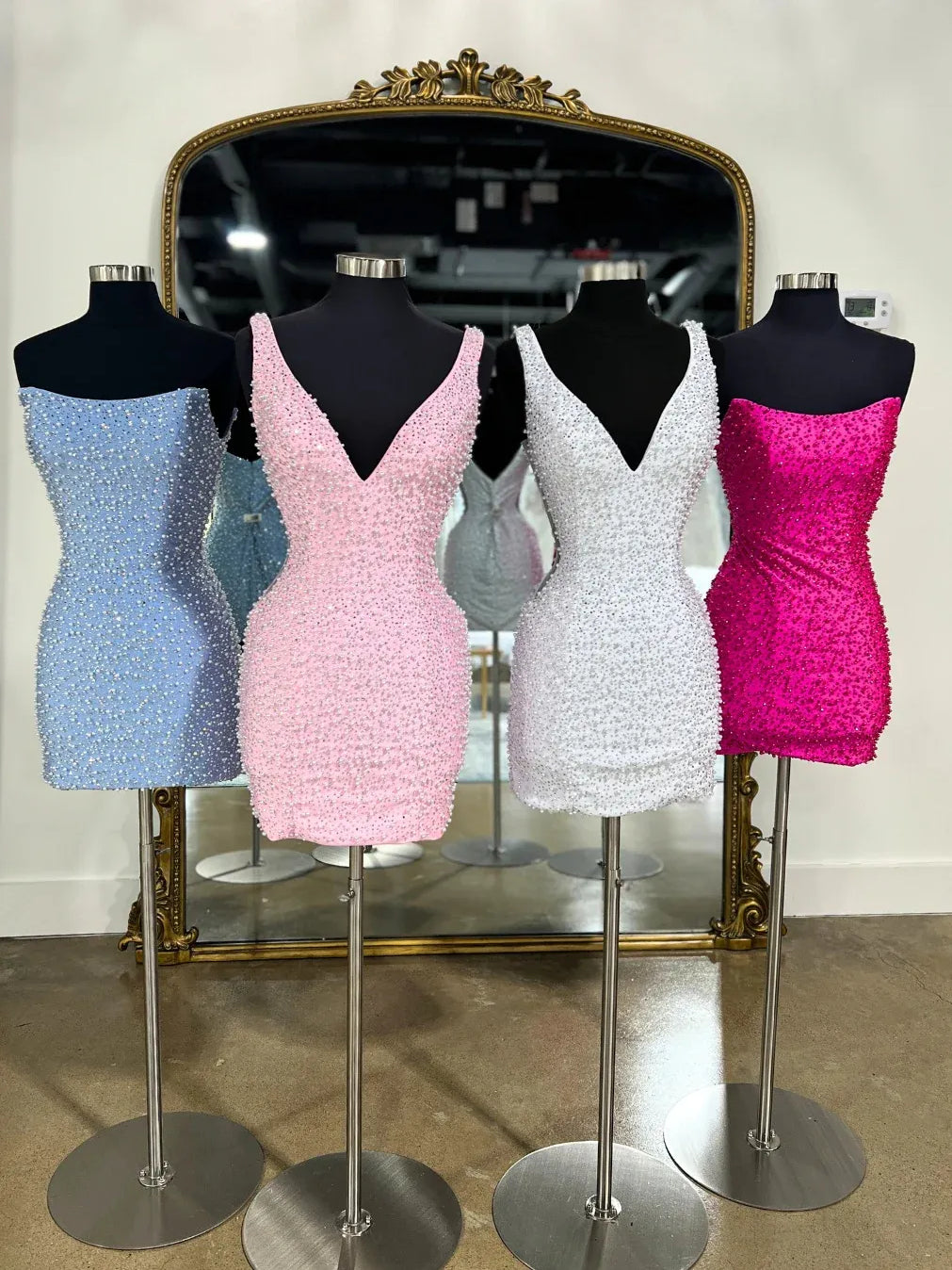 Beaded V-neck mini dresses in light blue, blush, white, and hot pink on mannequins