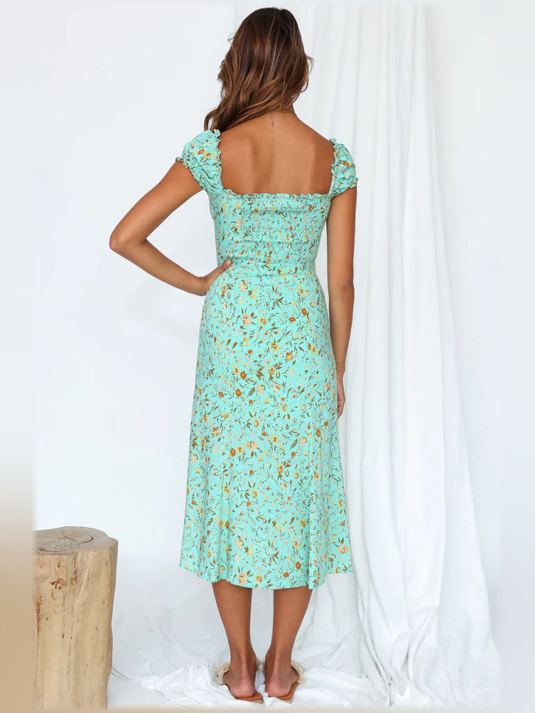 Back view of aqua floral midi off-shoulder dress with ruffle sleeves and center slit.