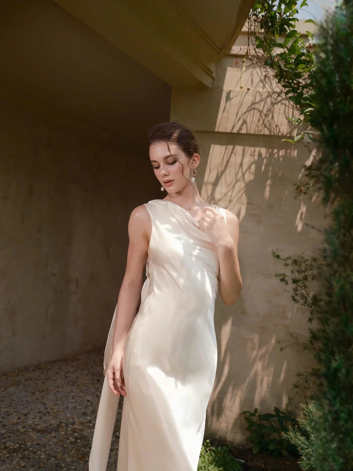 Ivory satin sleeveless sheath wedding dress with draped cowl neckline and floor-length hem