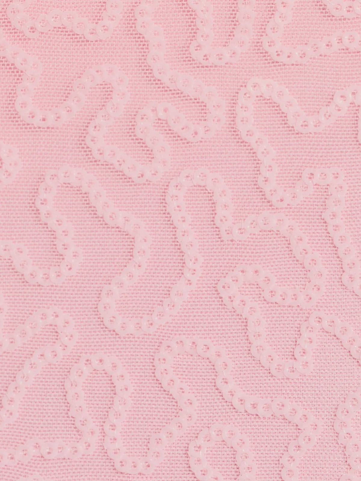 Sequin fabric close-up, soft pink with allover shimmer and textured pattern