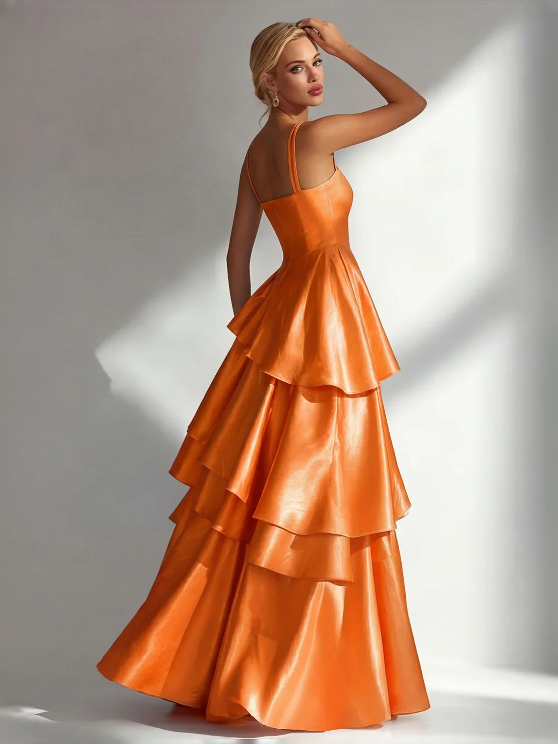 Burnt orange satin prom dress with square neckline, thin straps, and tiered ruffle A-line skirt.