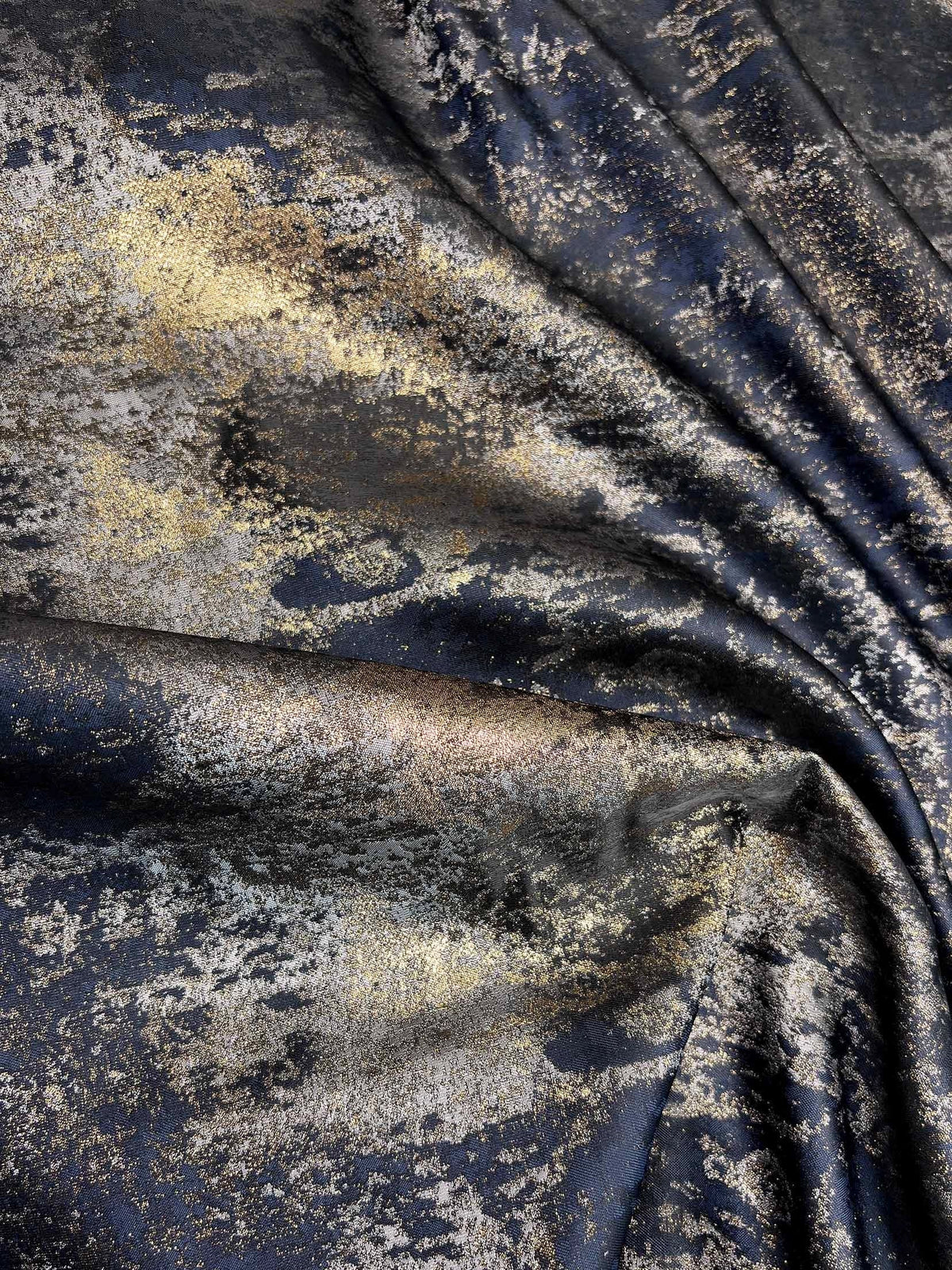 Navy and gold speckled fabric swatch with textured, shimmering finish