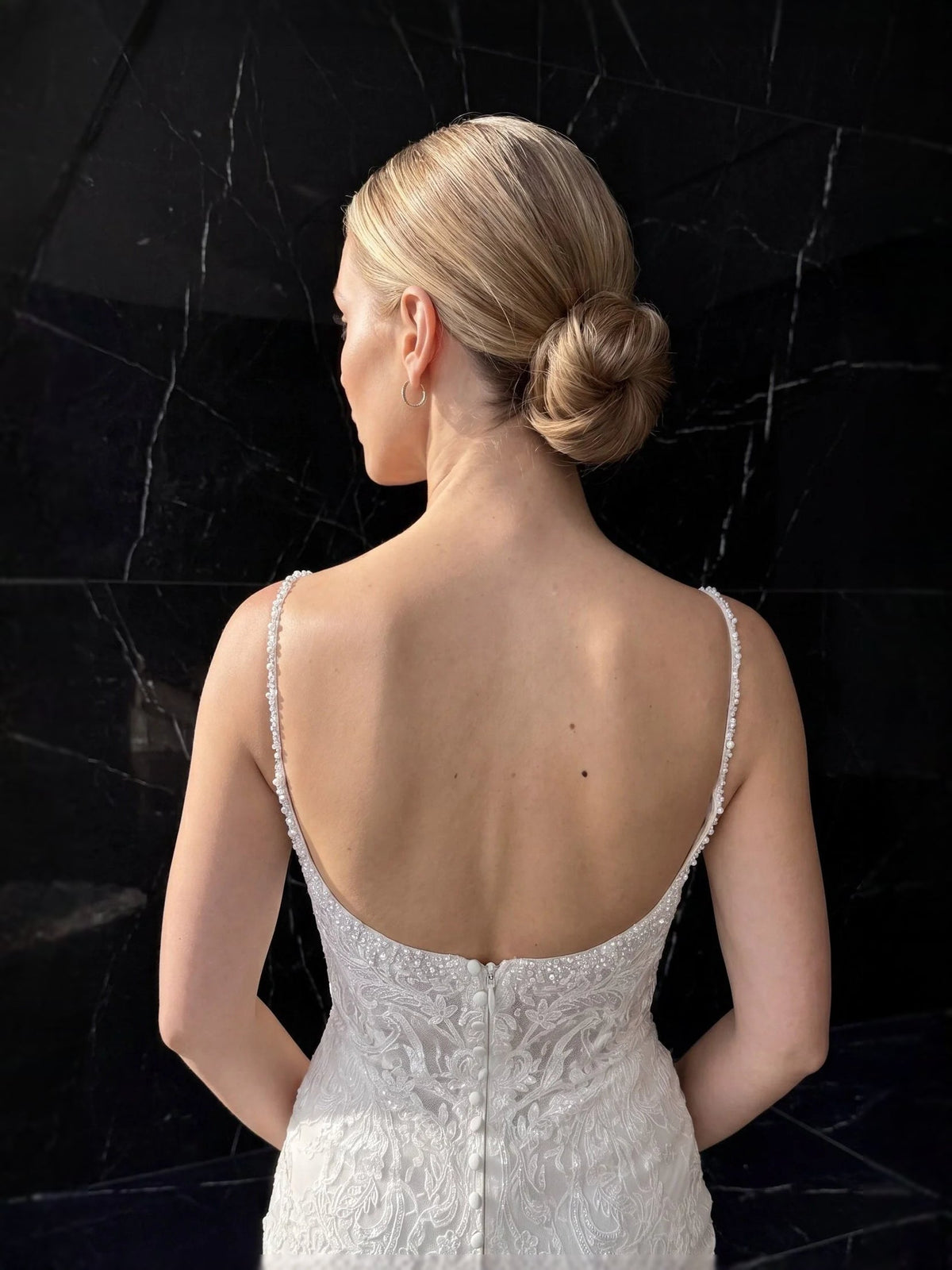 Back view of ivory beaded lace mermaid wedding dress with open back and thin straps