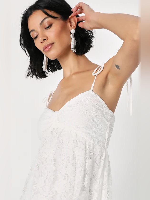 White lace mini dress with sweetheart neckline and open-back tie straps with tassels.