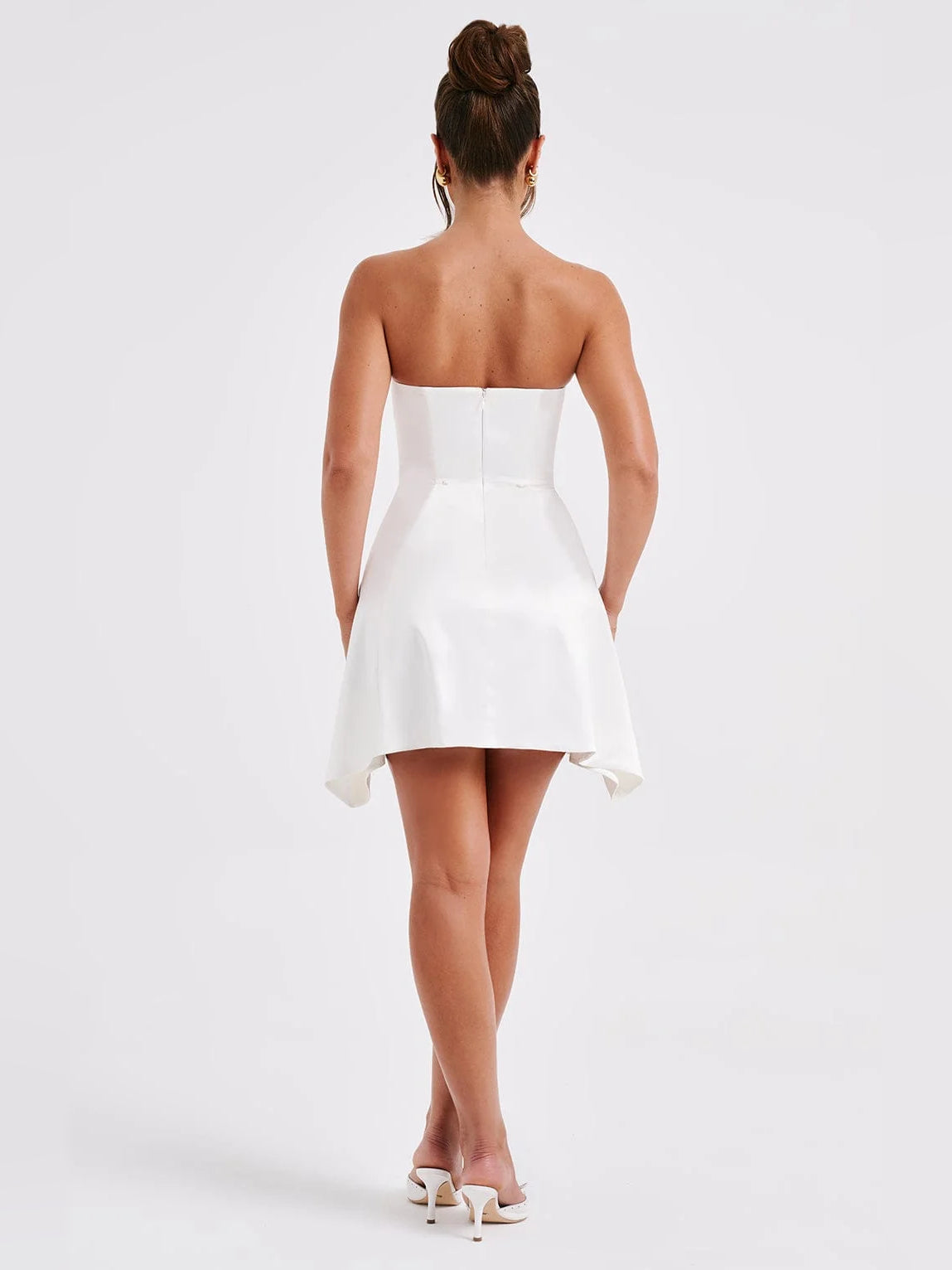 Ivory strapless mini dress, back view, with peplum-like flare and hem tails