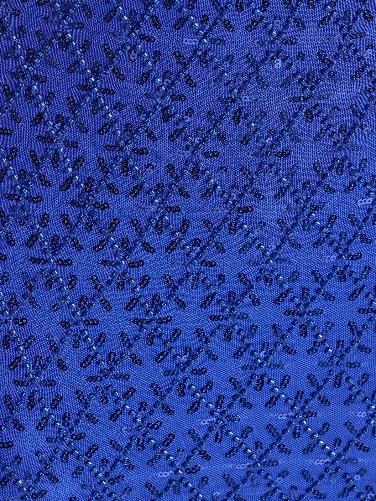 Close-up of royal blue sequin fabric with diamond pattern texture