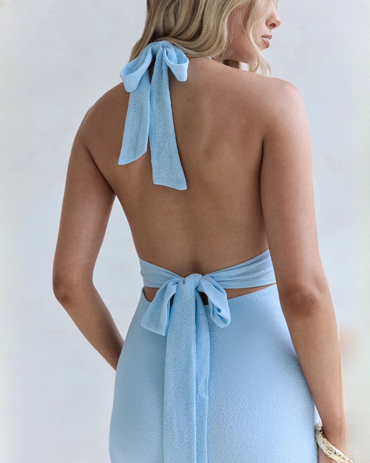 Light blue halter neck satin maxi bridesmaid dress, back view showing open lower back