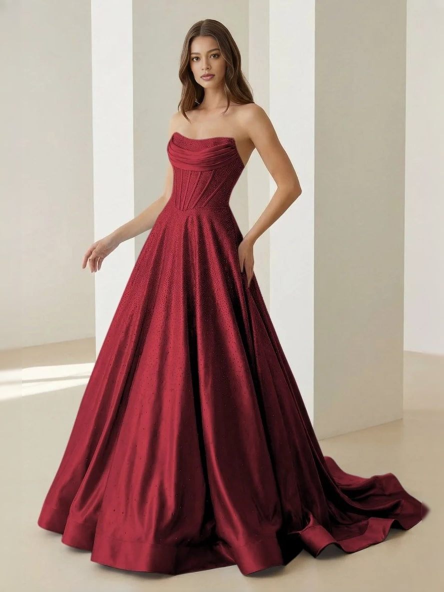 Burgundy strapless draped corset ball gown with full floor-length skirt