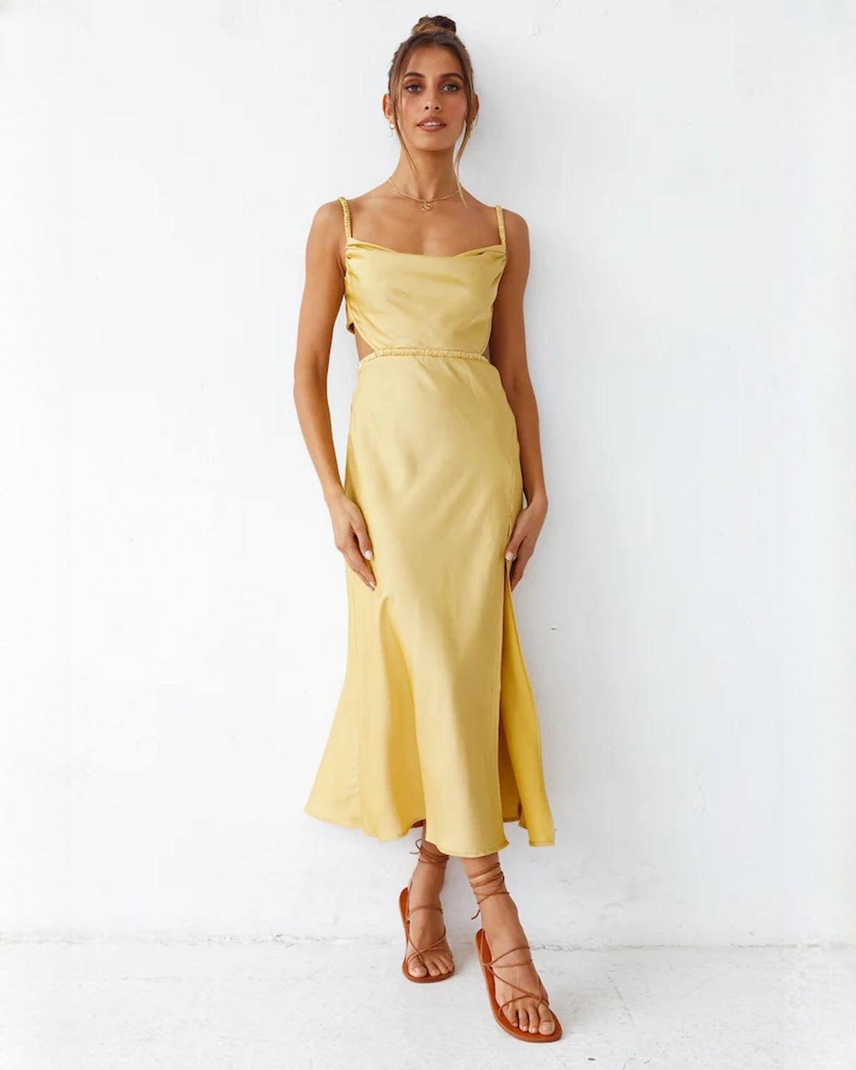 Yellow satin A-line maxi dress with square neckline, thin straps, and side slit