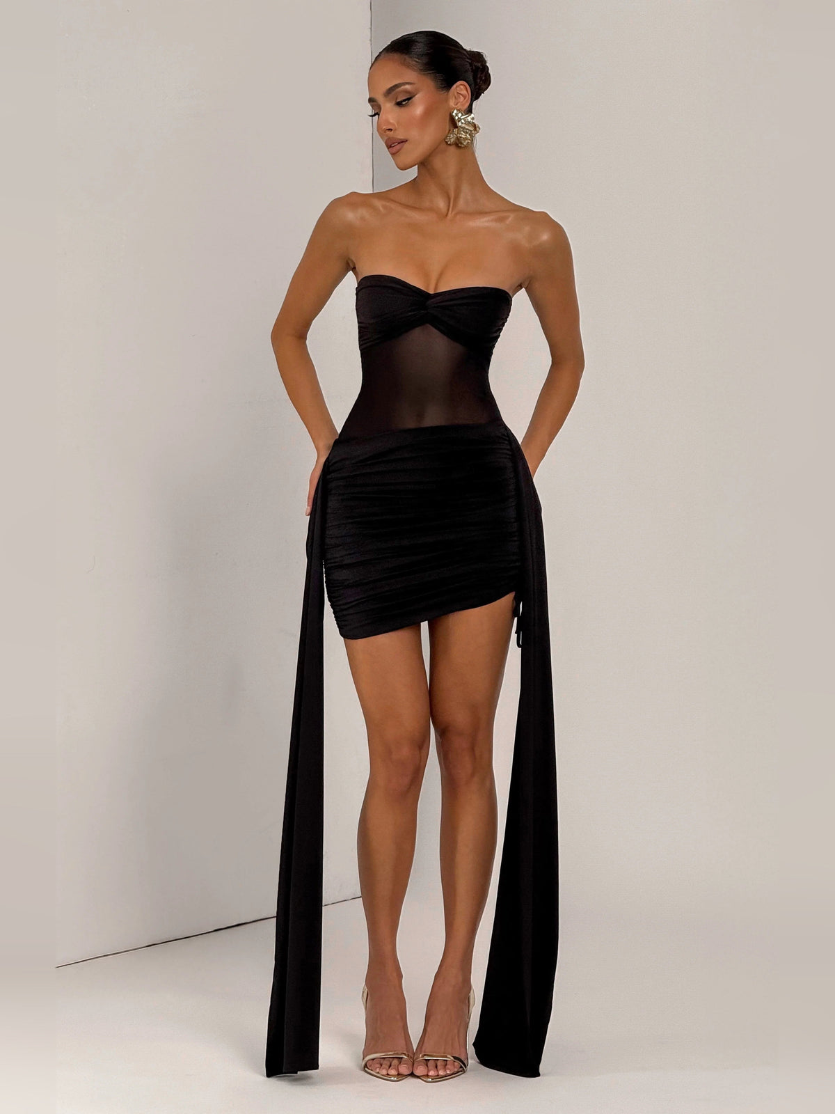 Black bandeau mini dress with ruched center panel and long draped chiffon train