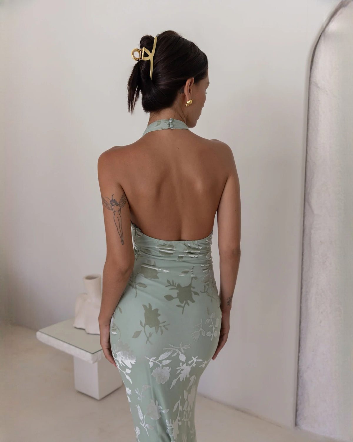 Back view: dusty sage floral sleeveless halter A-line maxi dress with open back