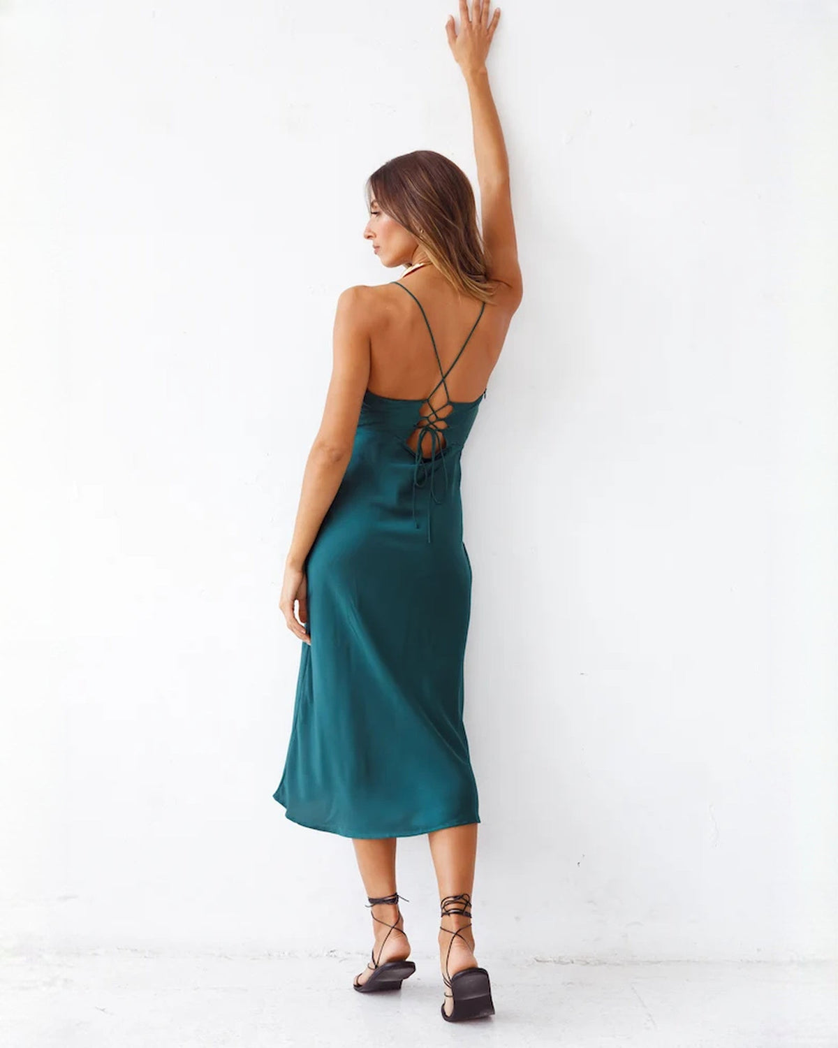 Deep teal satin midi dress from the back, open crisscross strap design