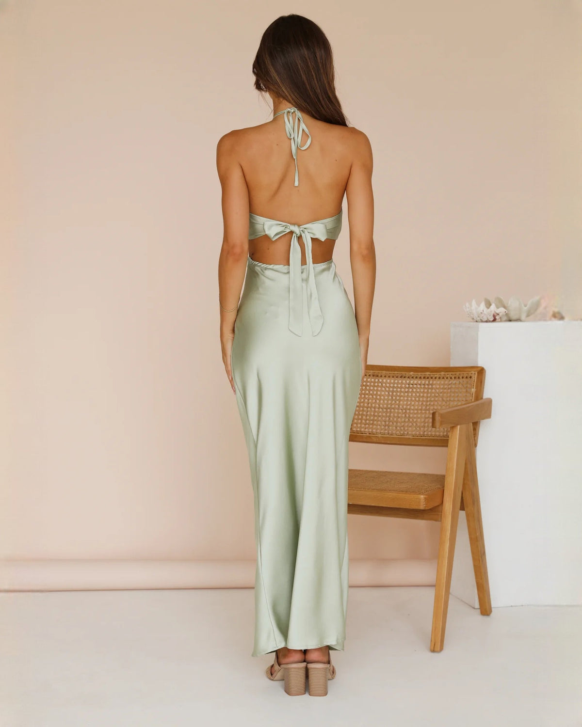 Back view of mint green satin halter maxi dress with open tie-back