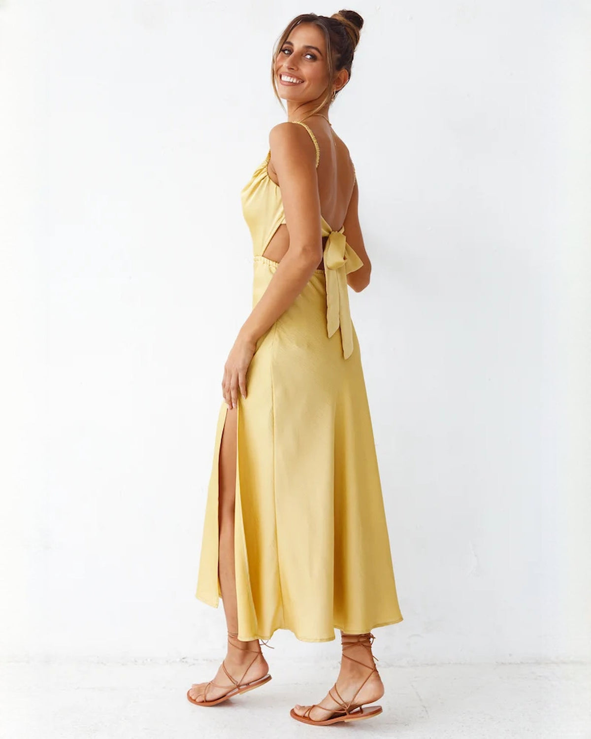 Yellow satin sleeveless A-line maxi dress with back bow detail and front slit