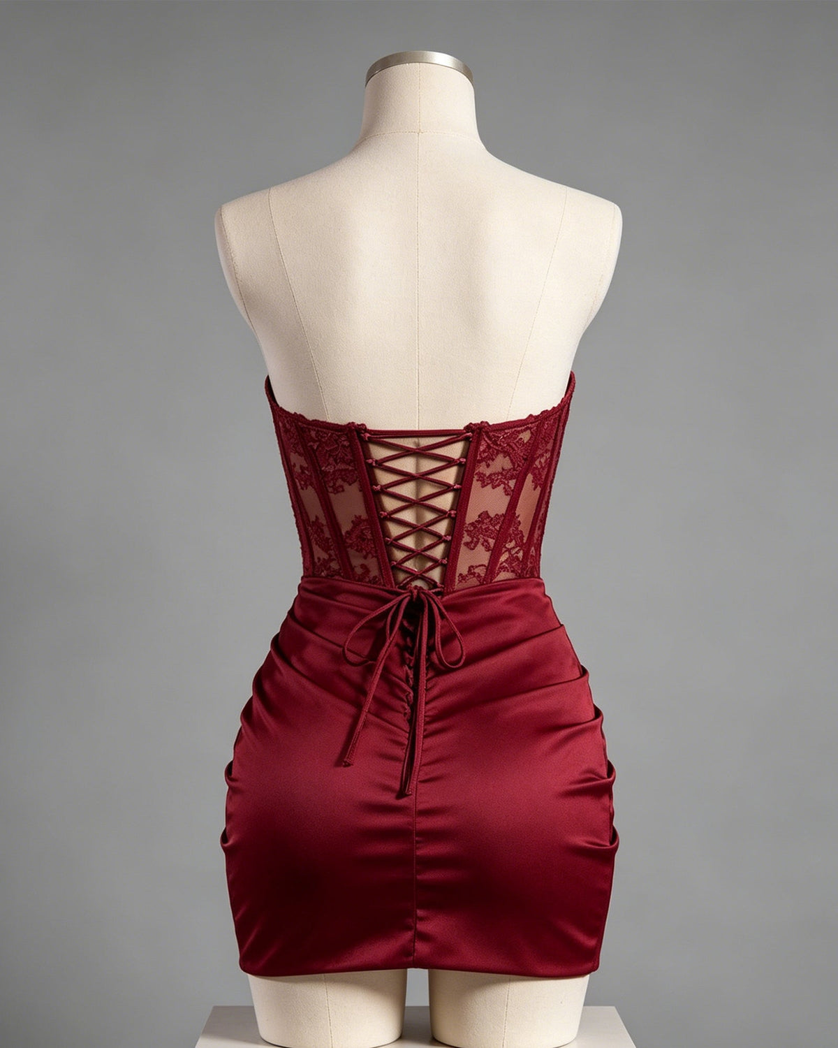 Burgundy ruched satin mini dress with lace corset back on mannequin
