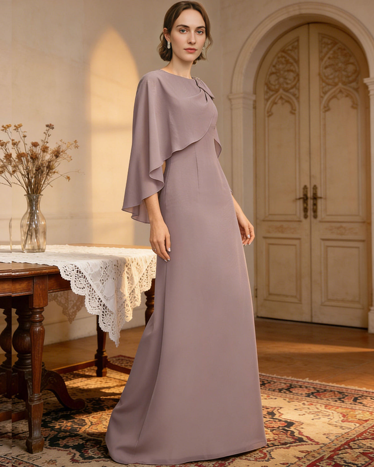 long cape sleeve mother of the bride dress with jewel neckline, bow shoulder, and chiffon column skirt shown in formal wedding guest styling