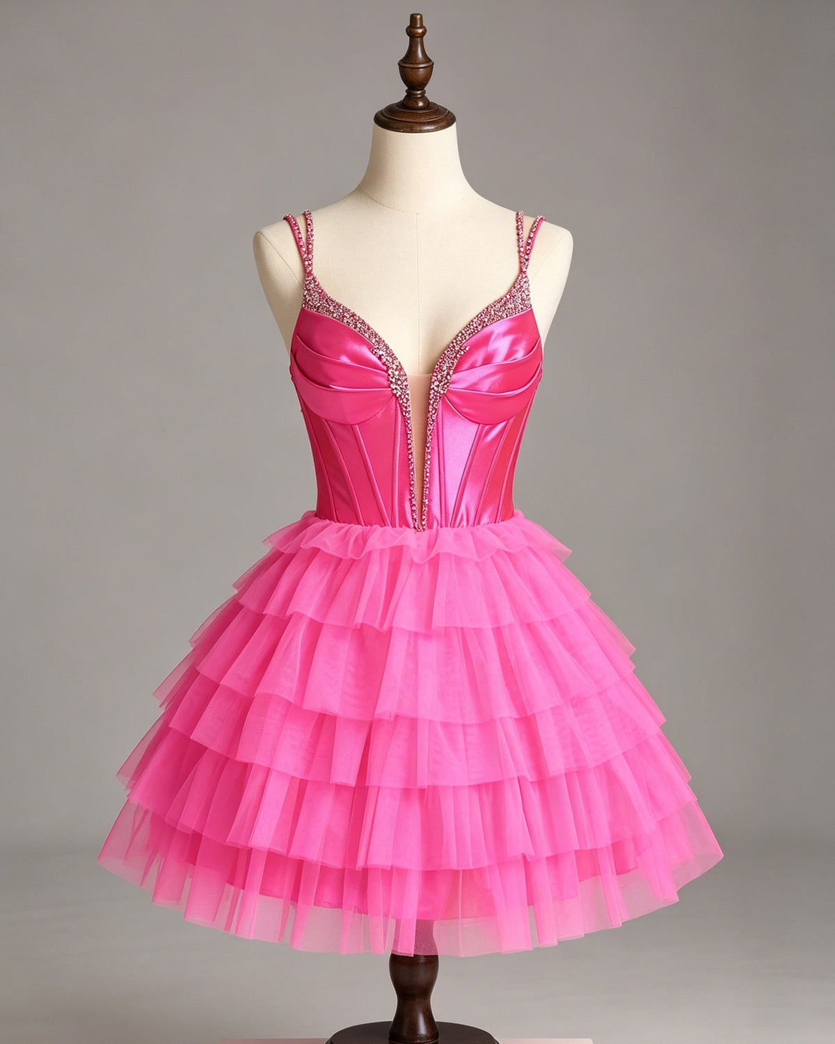 Pink beaded corset homecoming dress on mannequin with tiered tulle skirt