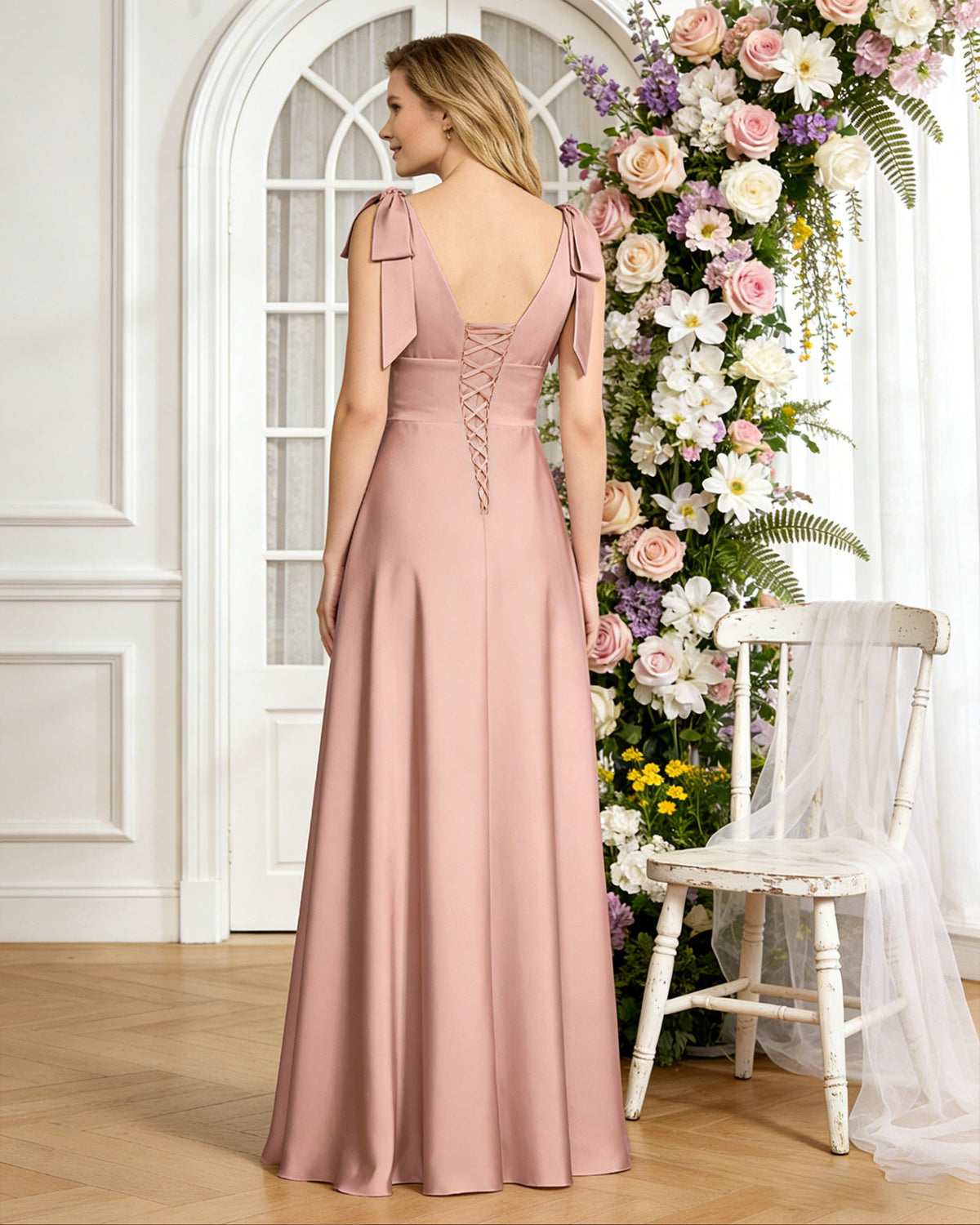 Blush satin V-neck bridesmaid dress with bow shoulder straps and empire waist, back view