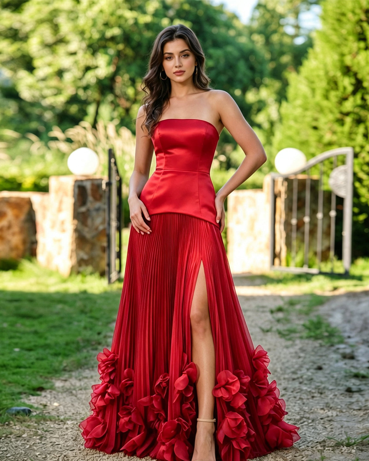 Red strapless formal dress with pleated skirt, front slit, and floral ruffle hem